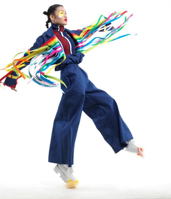 Woman performing a dynamic and energetic movement in a bright, clean space.